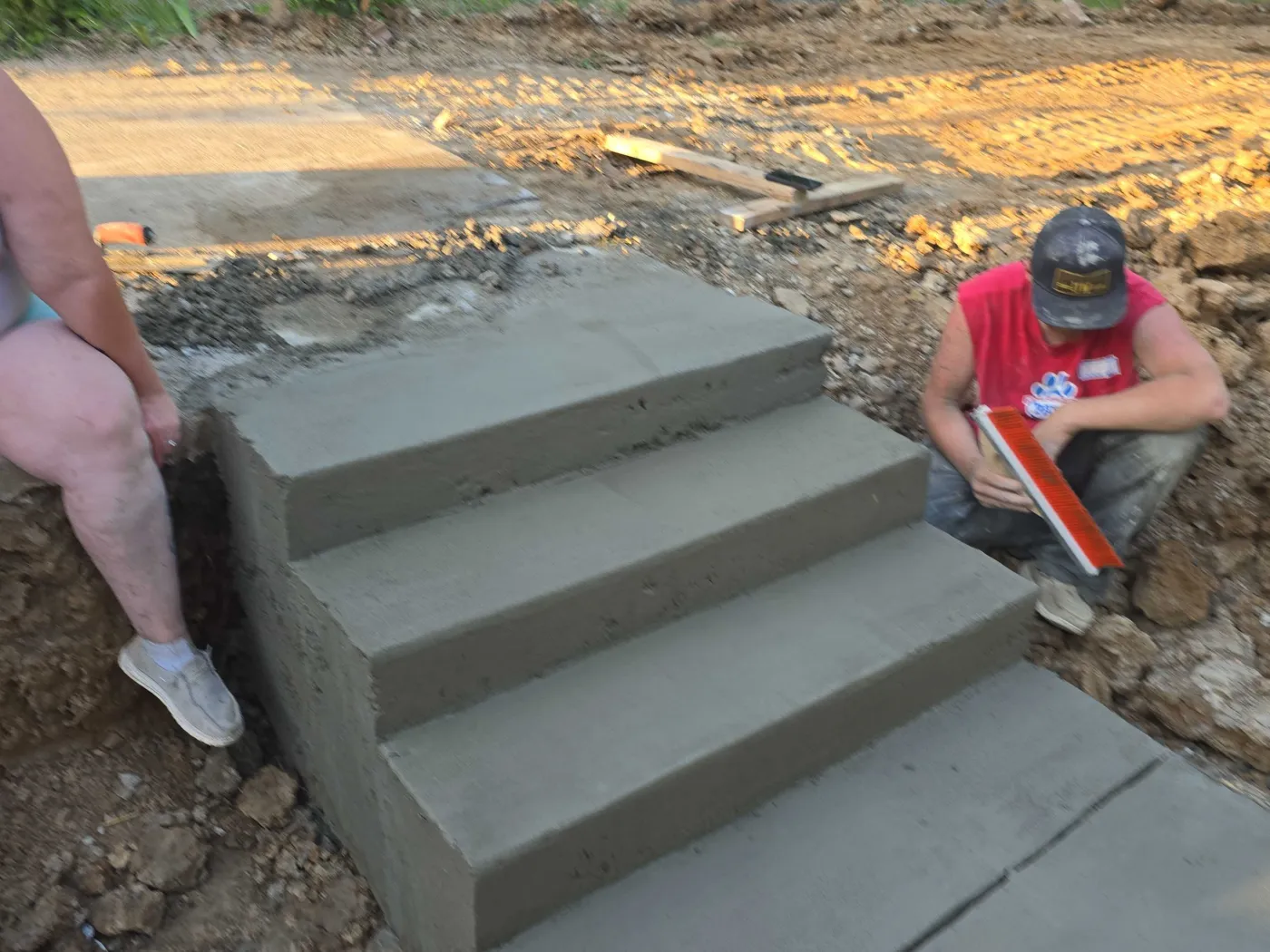 Crew hand-finishing a set of freshly poured concrete steps