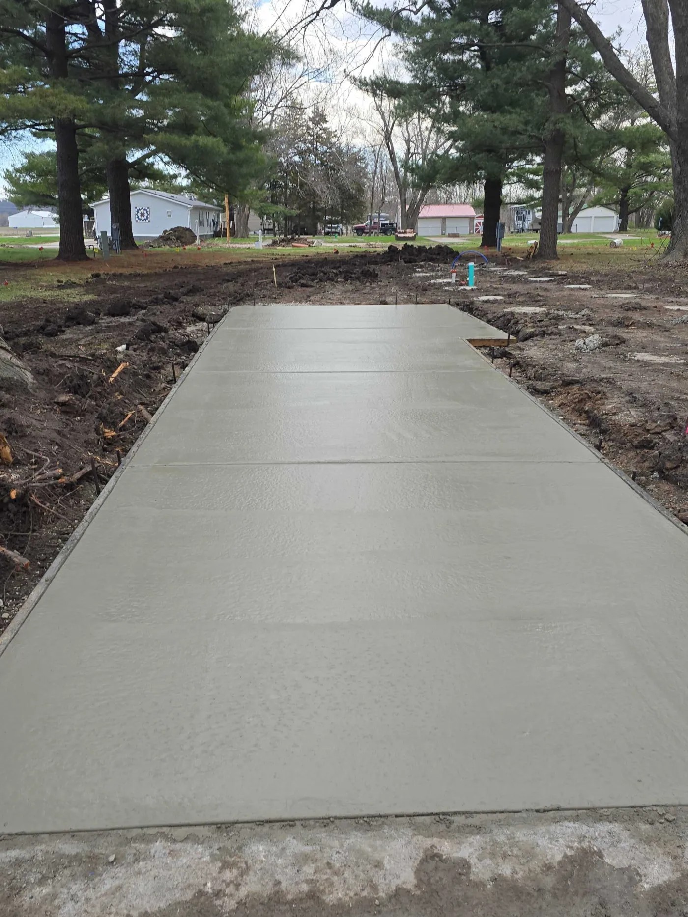 Long freshly poured concrete driveway by Ostermiller Construction