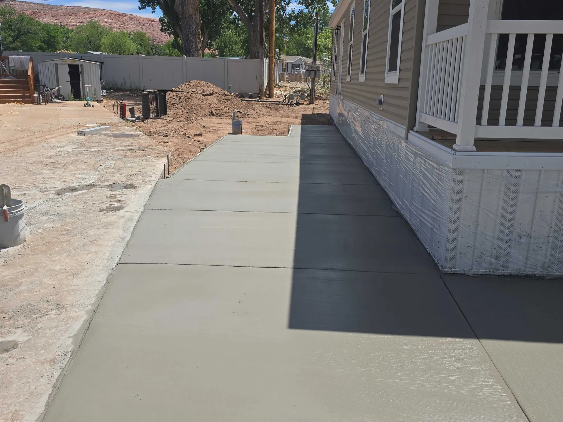 Fresh concrete sidewalk and patio poured by Ostermiller Construction